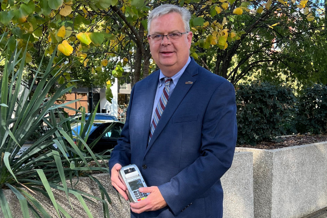 A photo of Jerry Hankins, Jr. holding a Credit Card Processing terminal. 